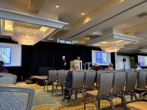 Photo of people sitting in chairs listening to a presentation.