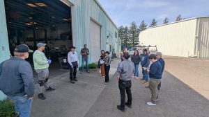 A group of people standing outside a large warehouse.