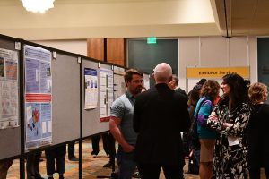 Attendees networking at an academic poster session.