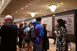 Attendees networking at an academic poster session.
