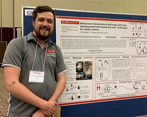 A photo of Dr Hayes standing in front of a scientific poster.