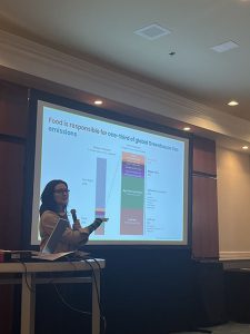 Speaker holding microphone pointing at screen.